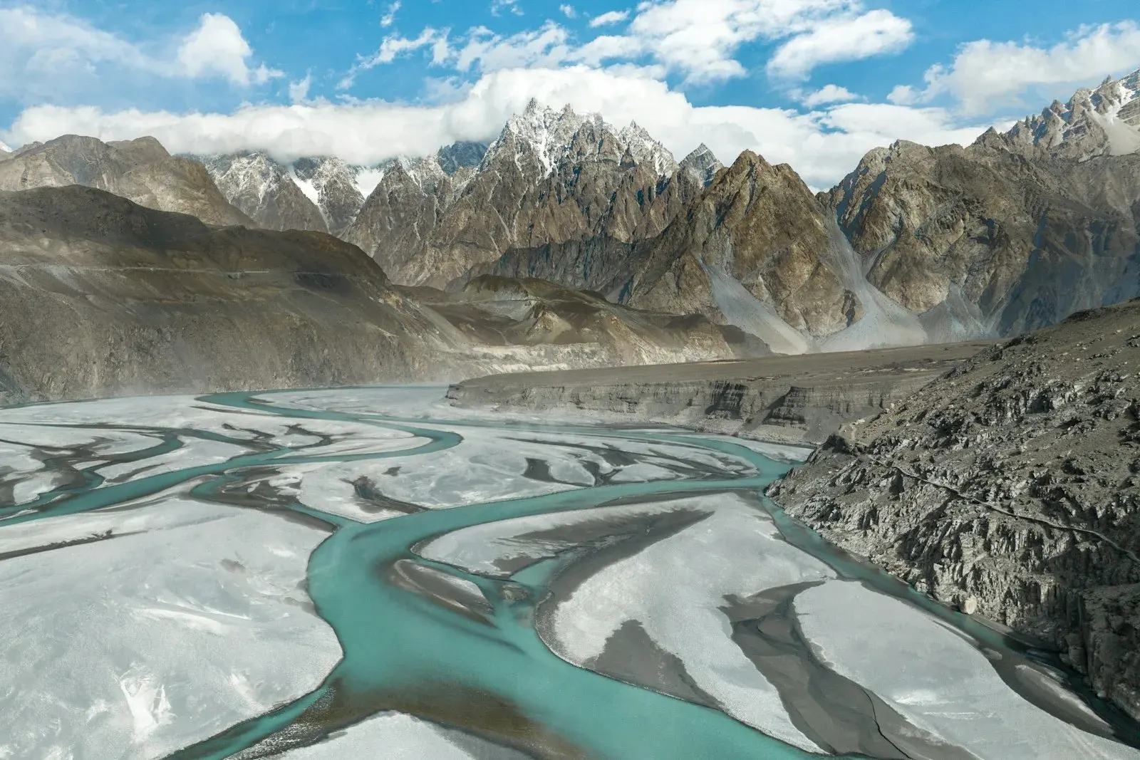 River running through a valley with mountains behind
