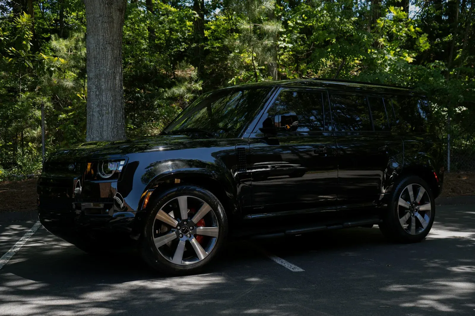 Black SUV parked under trees